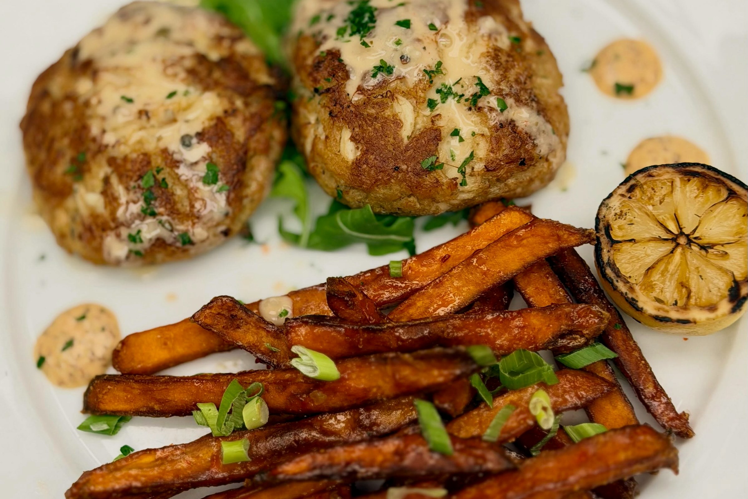 Chesapeake crab cakes with sweet potato fries and a charred lemon