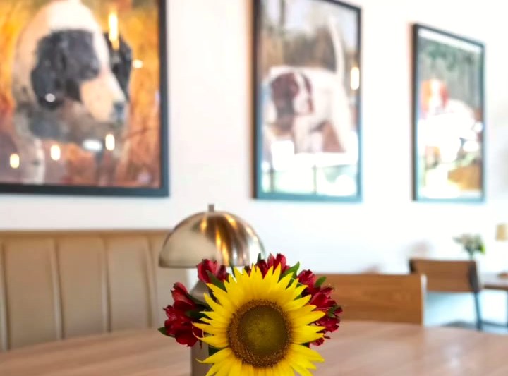Framed dog portraits along the dining room wall