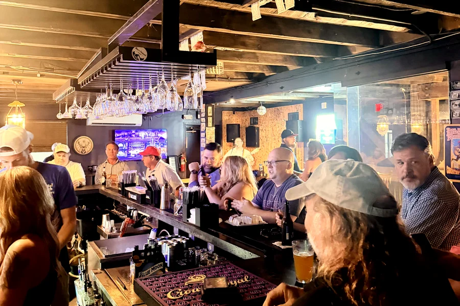 Foster's upstairs on a full night, the bar lined with people under the old beams